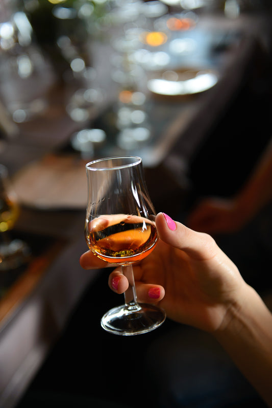 photo of a woman's hand holding a copita whiskey glass