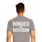 Shows man in grey shirt with the logo on the back that reads, Bonded by Bourbon in white lettering 