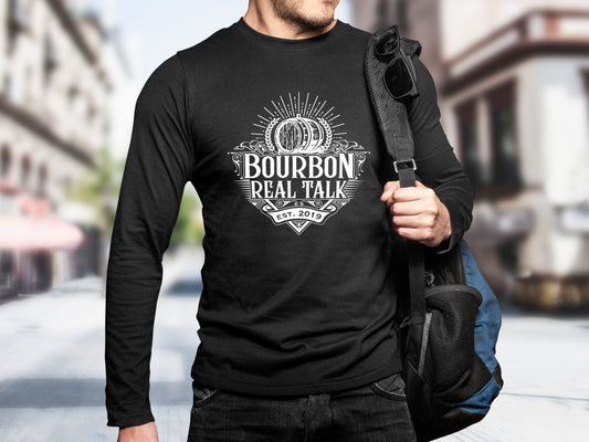 Man wearing a long sleeved Bourbon Real Talk shirt with a white logo, holding a backpack.