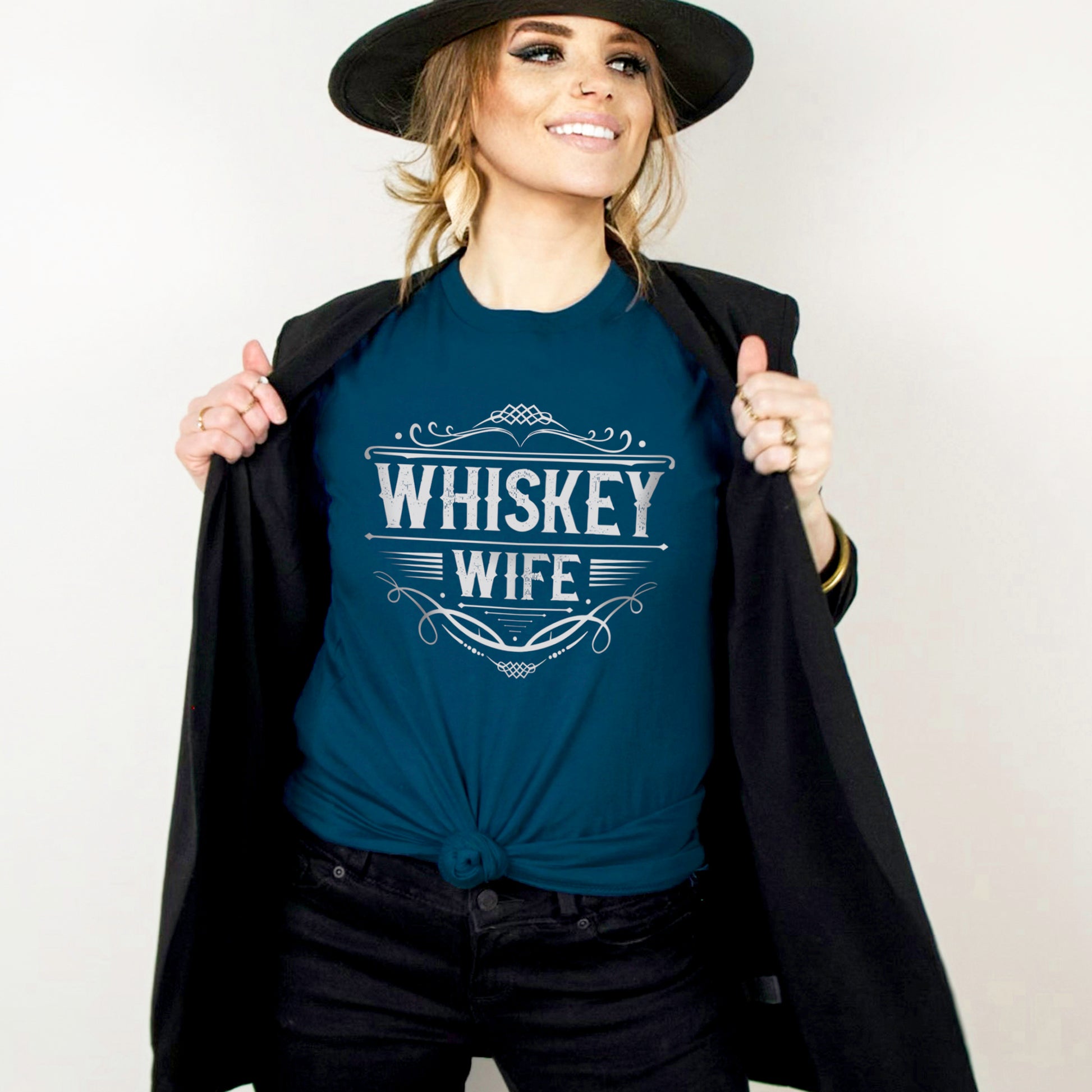 Woman wearing a dark teal whiskey wife shirt with a black blazer and felt hat