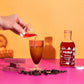 Camp Craft Hibiscus Simple Syrup on bright background with fresh hibiscus, sugar cube, pouring simple into a cocktail.